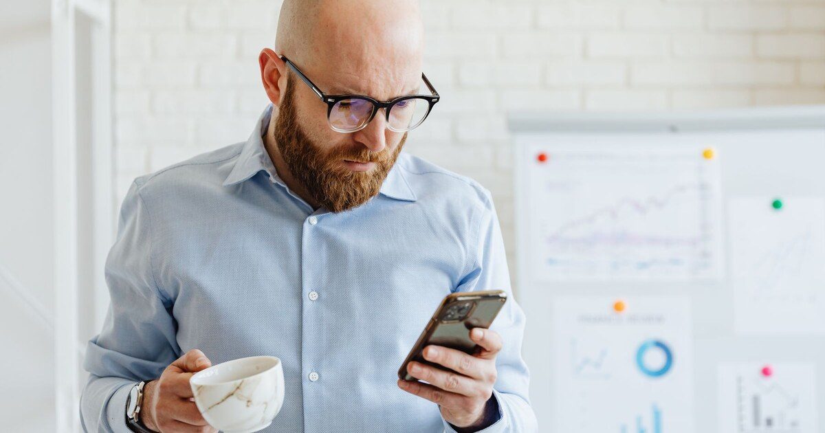 Professionnel vérifiant un avis sur son smartphone