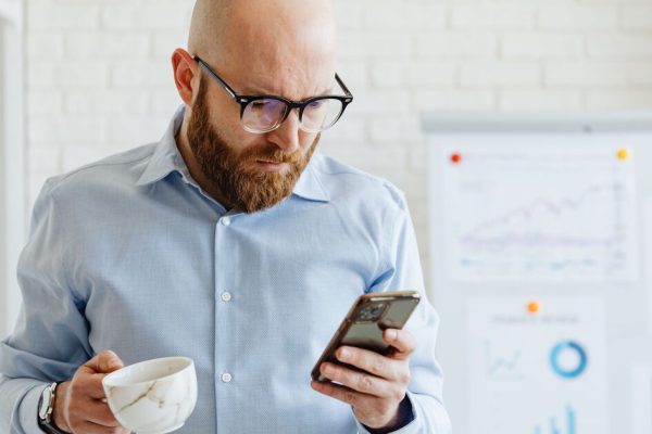 Professionnel vérifiant un avis sur son smartphone